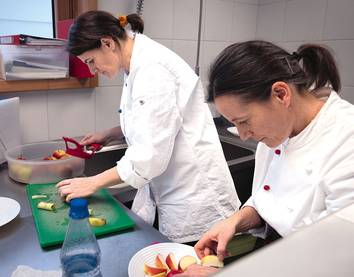 Zwei Frauen bereiten Äpfelschnitze in der Küche vor
